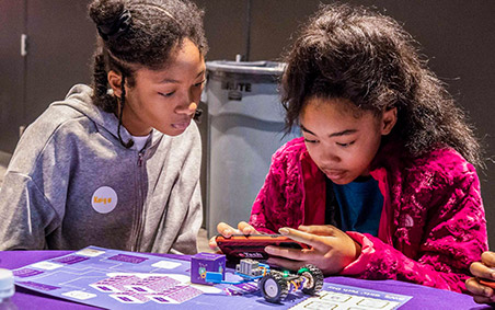 Image of two girls using robot