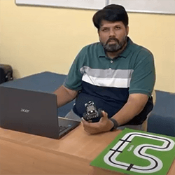 Image of Director of SVV School sitting with Quarky Robot