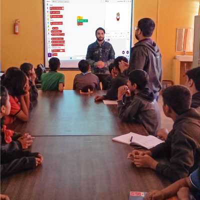 An image from the training session at KV Gandhinagar where the STEMpedia's Expert Trainer training the students on AI, Coding, and Robotics