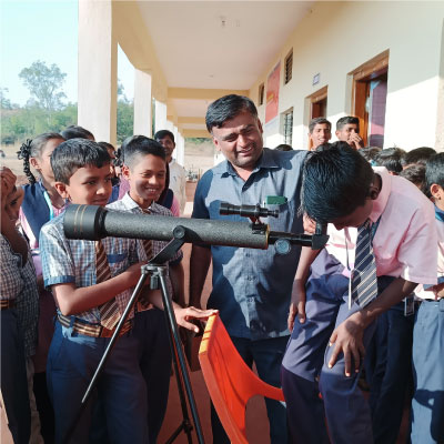 A curious student from Vishwa Gyan Vahini School engaging with the telescope with focused attention to understand the concept of celestial objects.